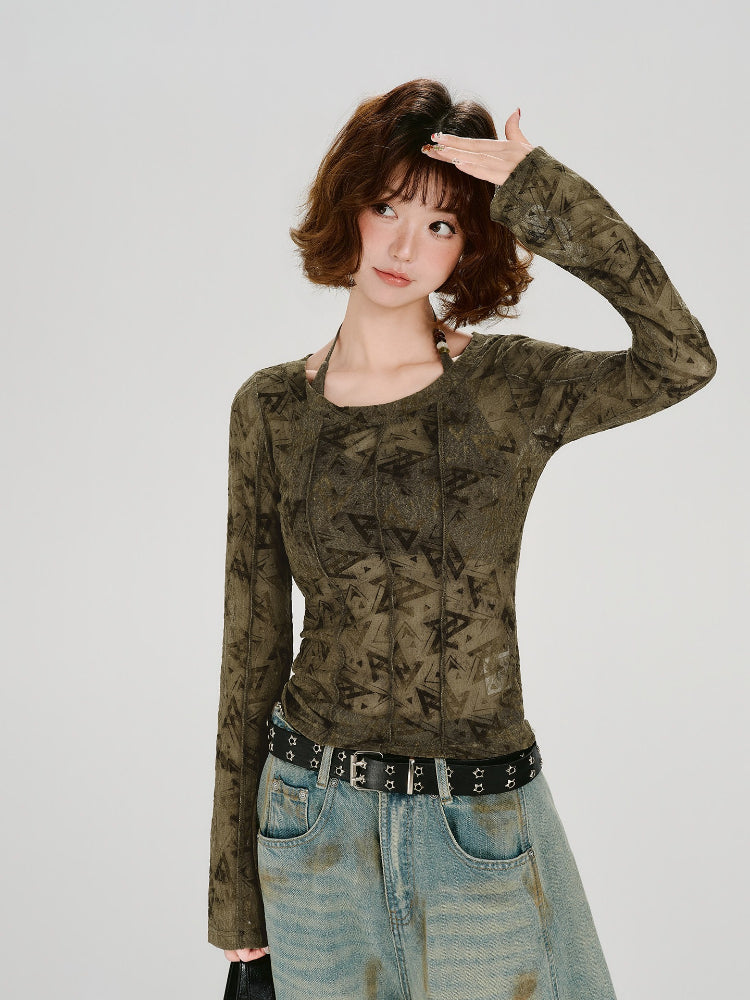 Woman wearing a long-sleeve olive green mesh top with a geometric triangle print, paired with light wash wide-leg jeans and a black belt.
