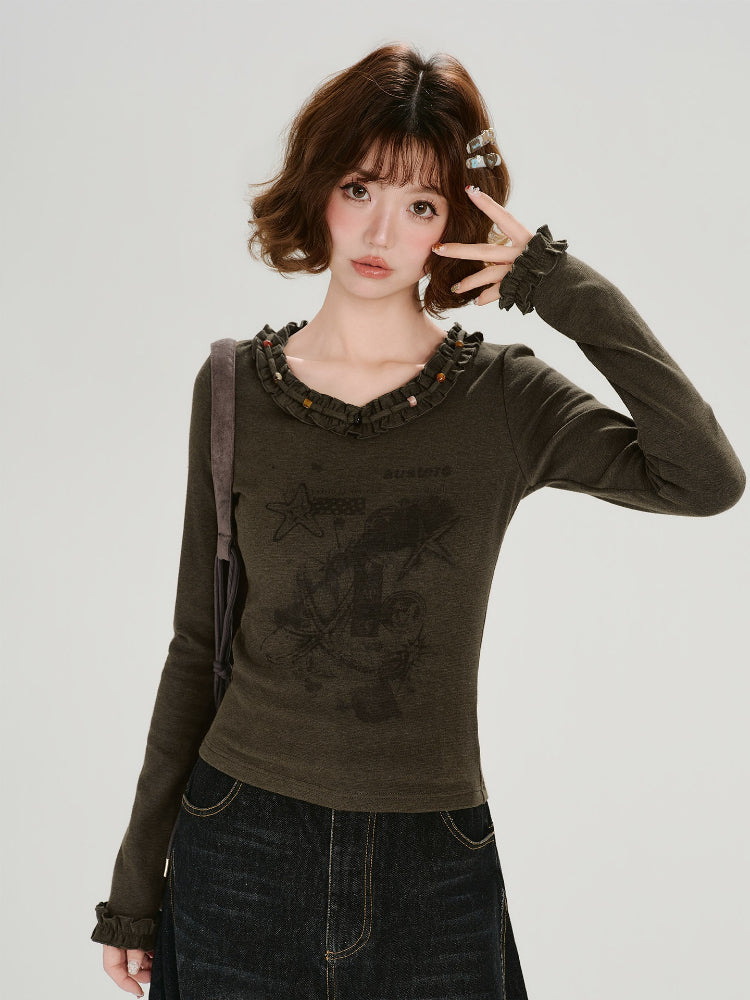 Close-up of the ruffled neckline with beaded trim on the graphic t-shirt.