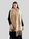 Model styled with a long, fringed beige scarf
