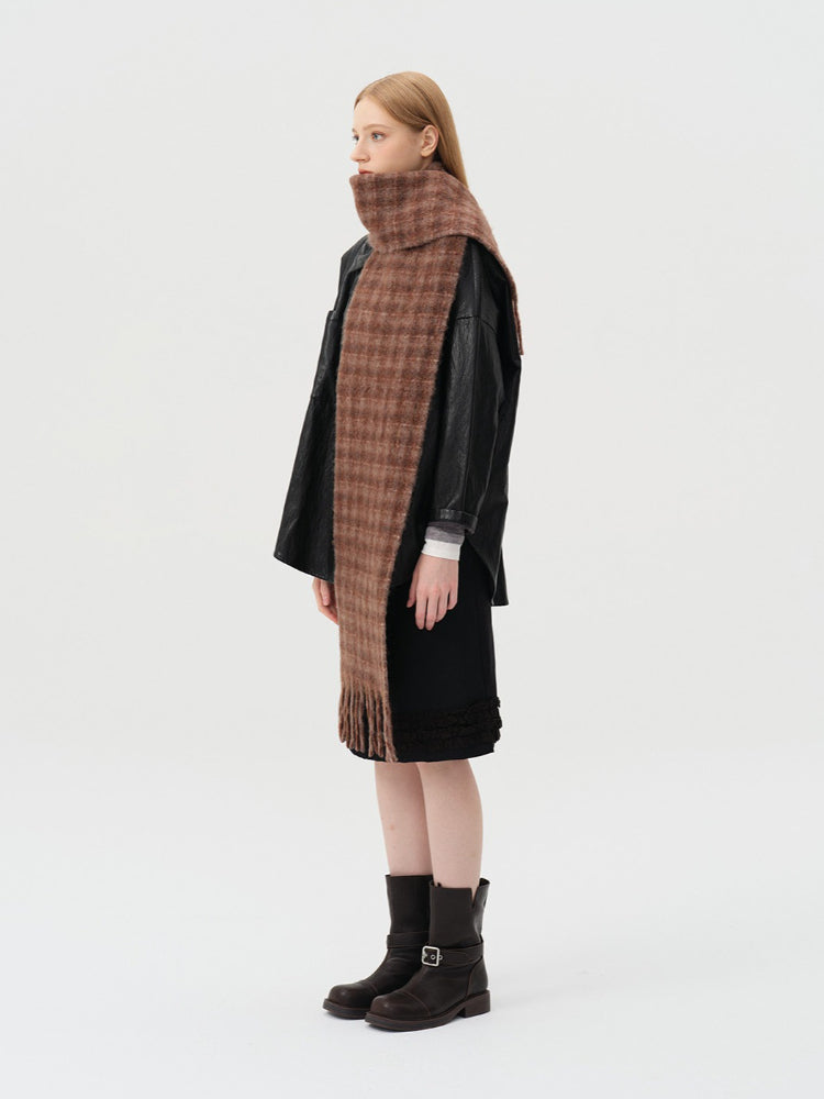 Woman modeling a wide brown tartan scarf with a high collar effect