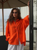 Woman in an orange oversized cotton shirt