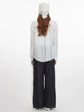 Back view of a woman in a light blue oversized button-down shirt