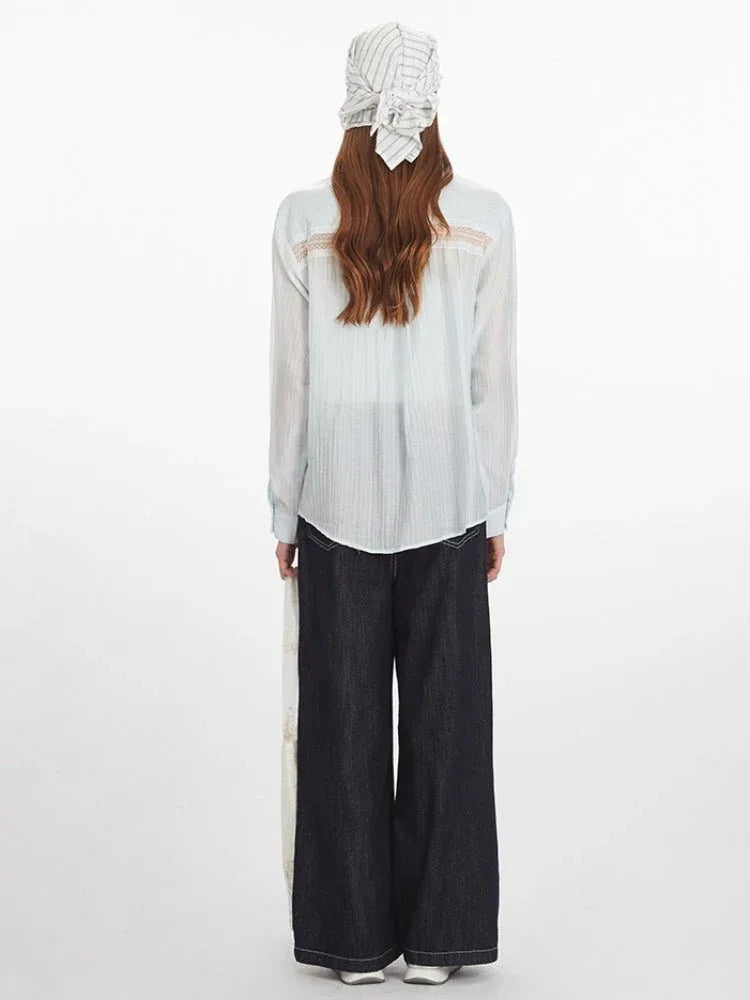 Back view of a woman in a light blue oversized button-down shirt