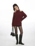 Front view of a woman in a burgundy cold shoulder halter neck sweater