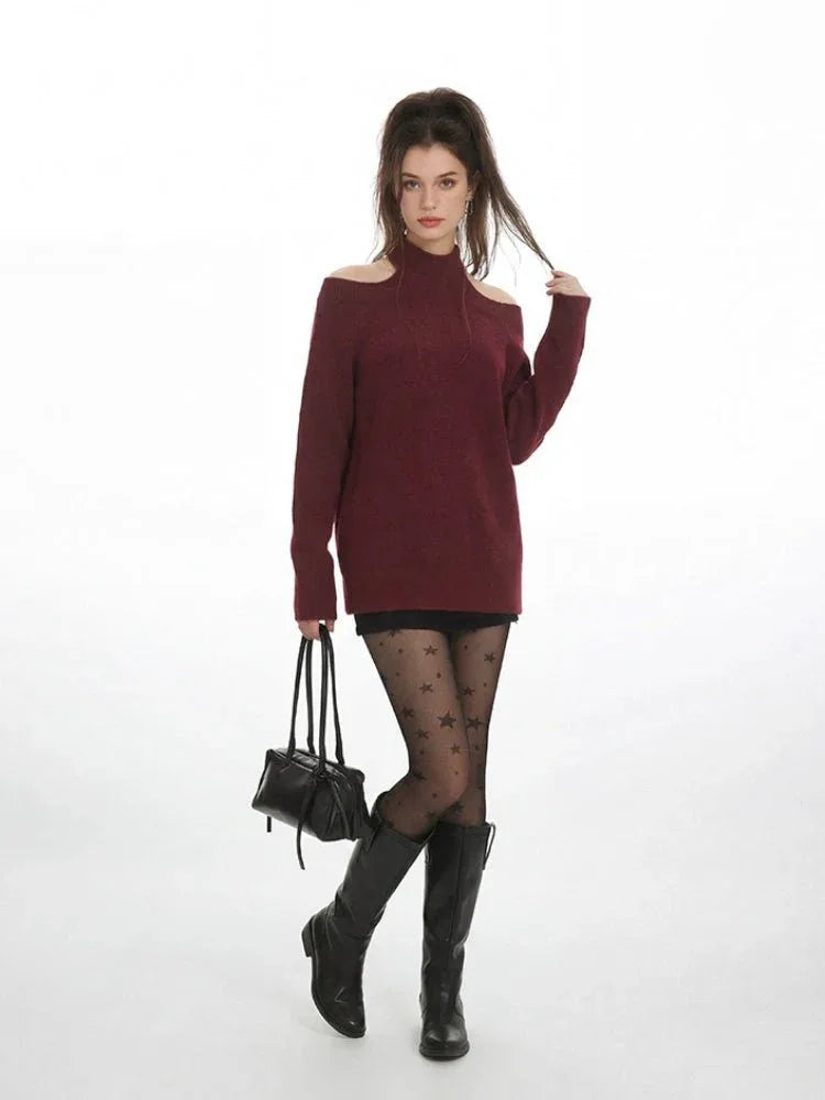Full body shot of a woman in a burgundy cold shoulder halter neck sweater