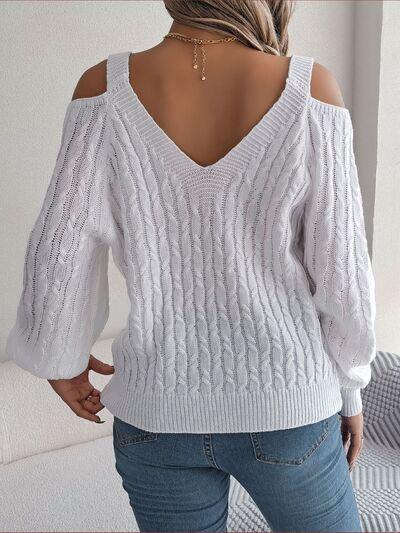 Back view of a woman in an ivory cold shoulder cable knit sweater