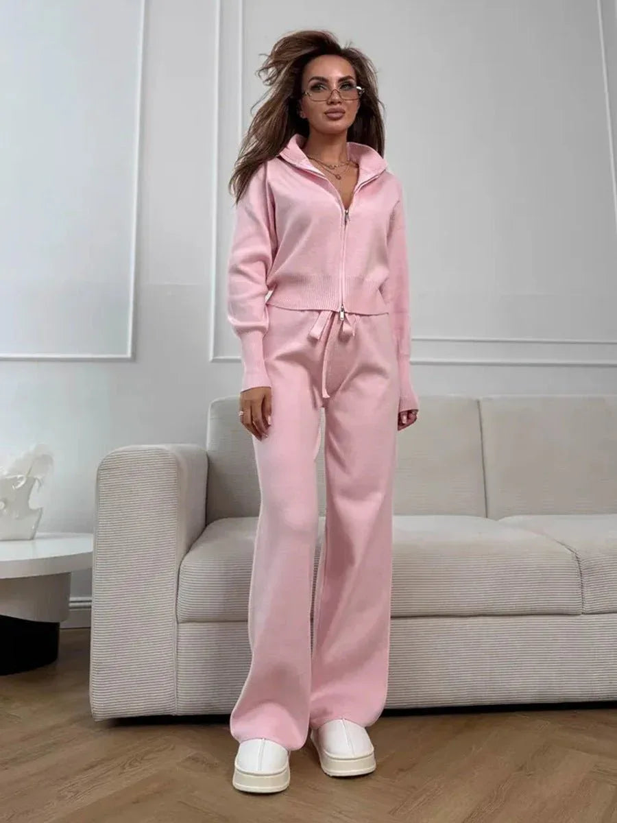 Model posing in beige knit set with double zip cardigan and wide leg pants