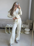 Woman in pink knit set with double zip cardigan and wide leg pants