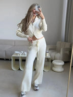 Woman in pink knit set with double zip cardigan and wide leg pants