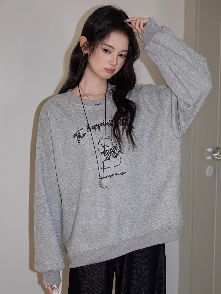 Model posing in a casual outfit featuring a graphic sweatshirt