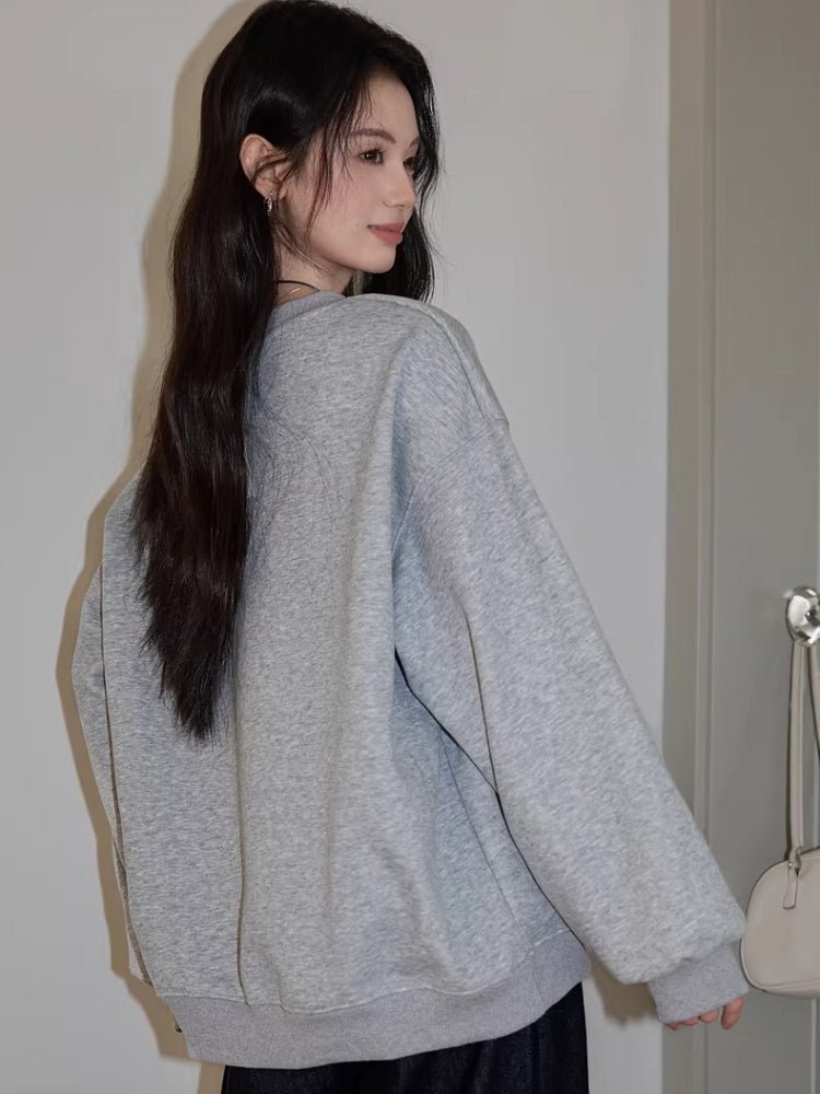 Woman wearing a heather grey embroidered puppy graphic sweatshirt