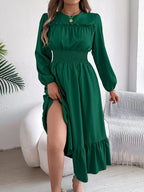 Woman in a green A-line dress lifting the hem to show her legs.