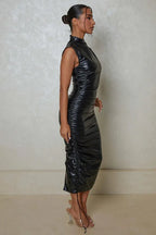 Profile of a woman in a black high collar PU leather dress