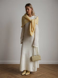 Model showcasing a white maxi dress and coordinating yellow scarf