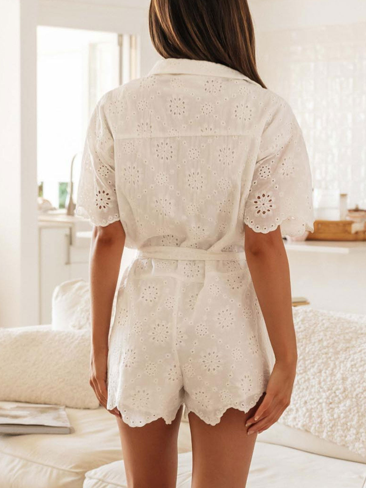Back view of a white short-sleeve romper with button front