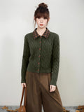 Close-up of the cable knit texture on a dark green cardigan.