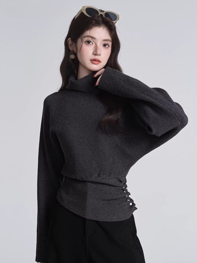 Woman wearing a dark grey high neck knit sweater with side buttons