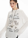 Model posing in a white long-sleeve sheer knit t-shirt with a black dog graphic print and text, black shorts, and black knee-high socks.