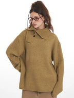 Woman in a camel oversized knit sweater with a button-up collar, showcasing the relaxed fit and textured fabric.