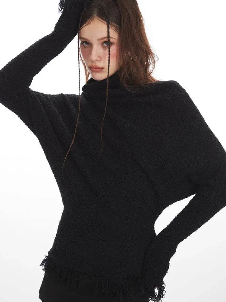 Close-up of a woman's face and shoulders wearing a black turtleneck sweater with dolman sleeves