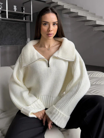 Woman wearing a white knit cropped sweater with a half-zip closure and wide collar.