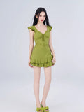 Full body shot of a woman in a lime green fit and flare mini dress with tiered ruffled hem.