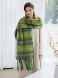 Full body shot of a woman modeling a green striped scarf with a beige coat