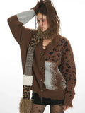 Woman posing with her hand on her head, showcasing a brown knit cardigan with contrasting fabric panels.