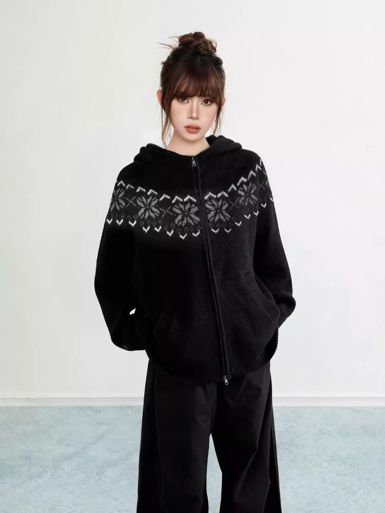 Woman wearing a black Fair Isle knit hoodie with snowflake pattern and zipper