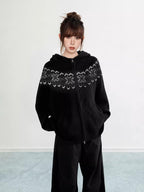 Woman wearing a black Fair Isle knit hoodie with snowflake pattern and zipper