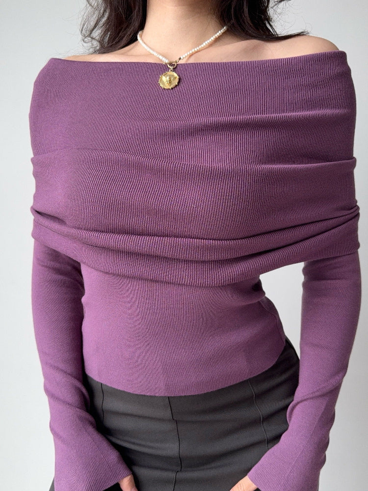 Detail of the draped neckline on a purple ribbed knit off-the-shoulder top.