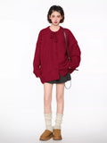 Full body shot of a woman in a red oversized knit cardigan with balloon sleeves.