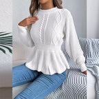 Close-up of a woman wearing a white peplum knit sweater with detailed stitching.