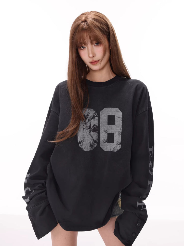 Model wearing a black long-sleeve graphic t-shirt with number '68' printed on the front and text on the sleeves.