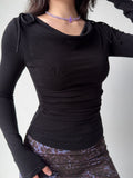 Close-up of a black long-sleeve top with ruching on the side.