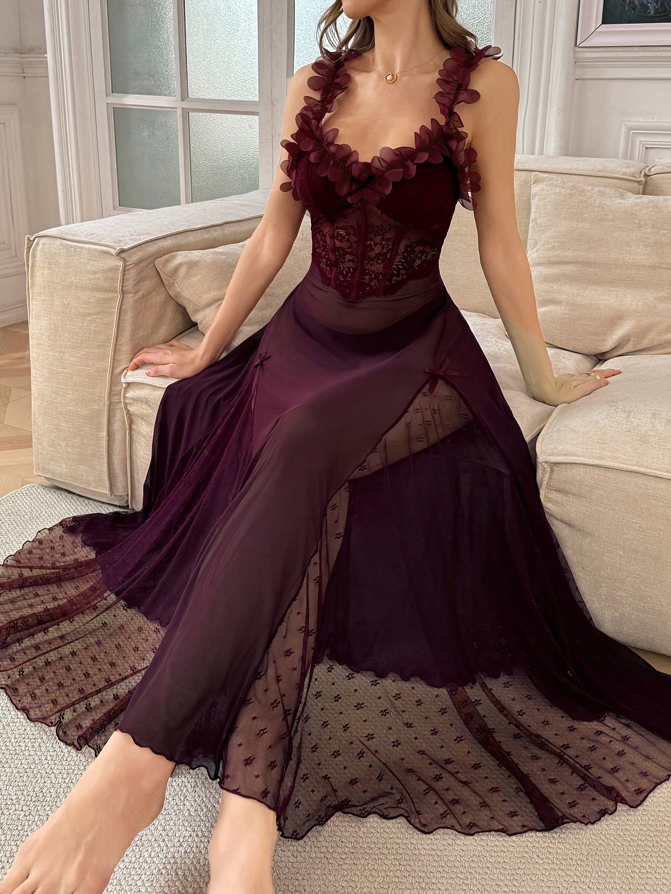 Full body shot of a woman in a plum maxi slip dress with sheer overlay and intricate floral embellishments on the neckline.