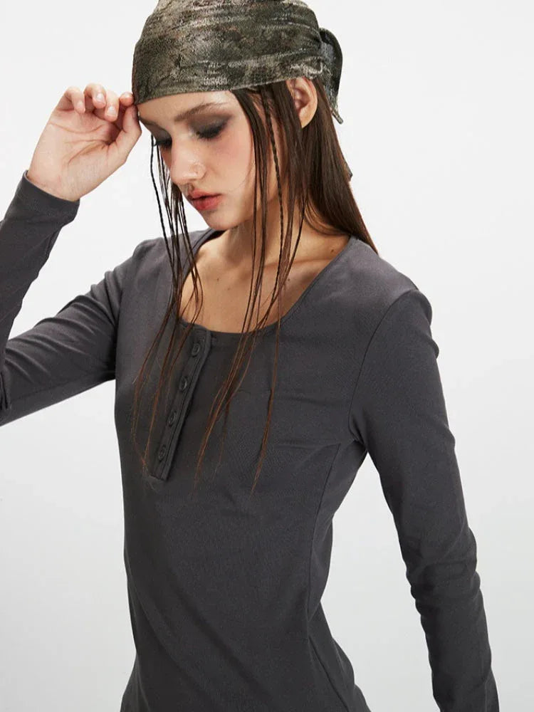Detail shot of the square neckline and buttoned placket of a dark grey long-sleeve ribbed knit top.
