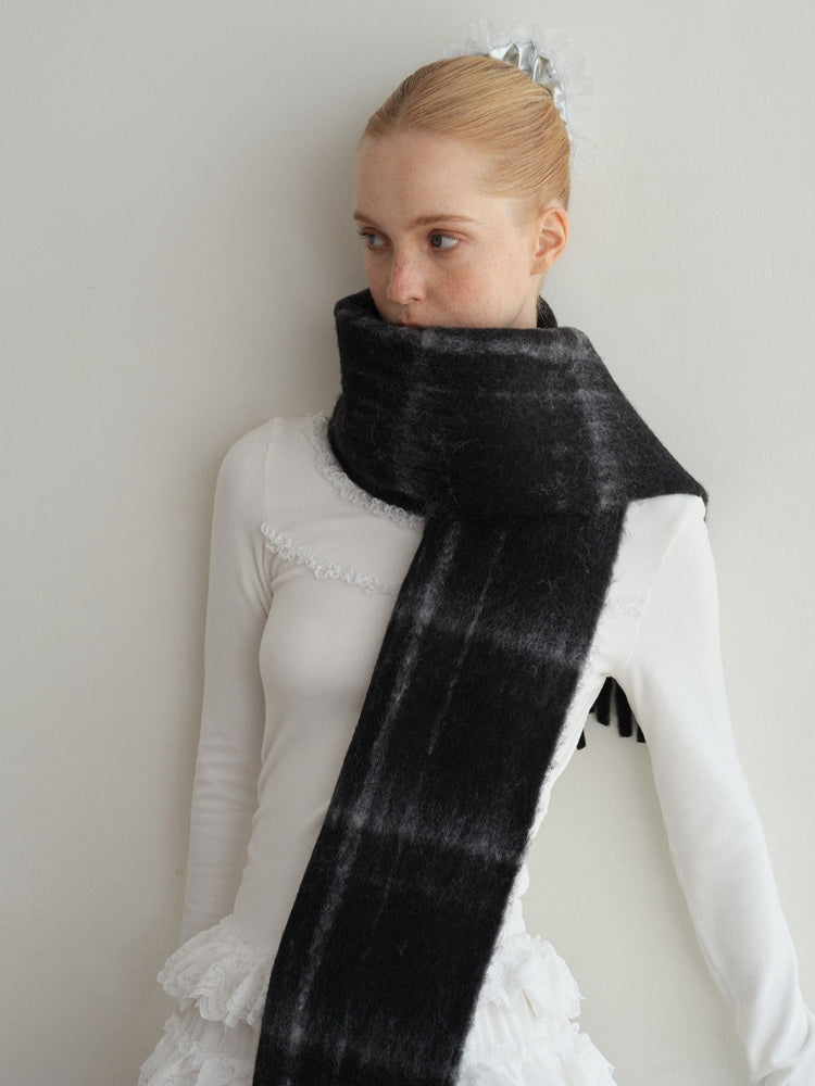 model posing with a long black and grey tartan scarf
