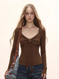 Woman with a shoulder bag wearing a long sleeve tie front blouse