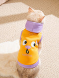 Rear view of a cat in a blue and yellow hooded pet vest with a 'Grievance' graphic.