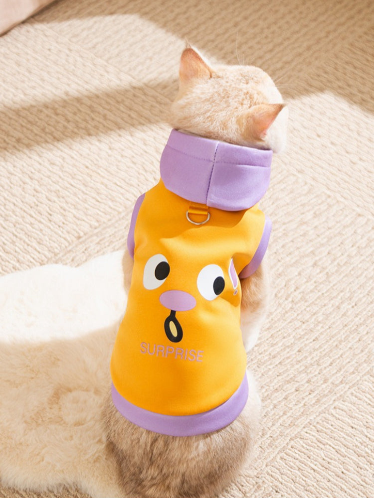 Rear view of a cat in a blue and yellow hooded pet vest with a 'Grievance' graphic.
