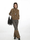 Model posing in a layered outfit featuring a faux fur vest and leg warmers.