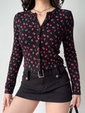 Model in a black floral print cardigan and black skirt, showcasing the garment's silhouette.
