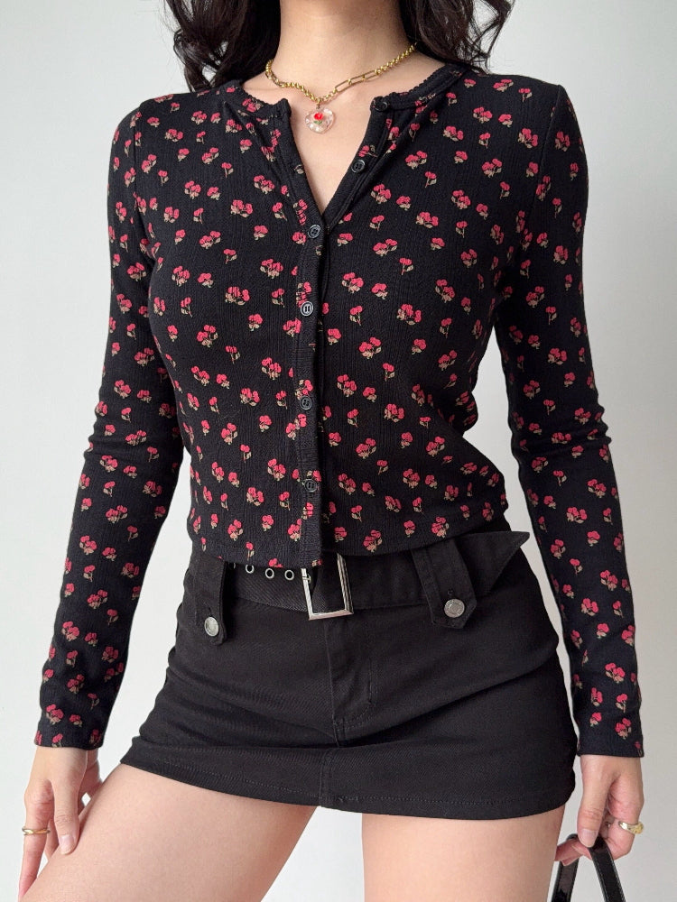 Model in a black floral print cardigan and black skirt, showcasing the garment's silhouette.