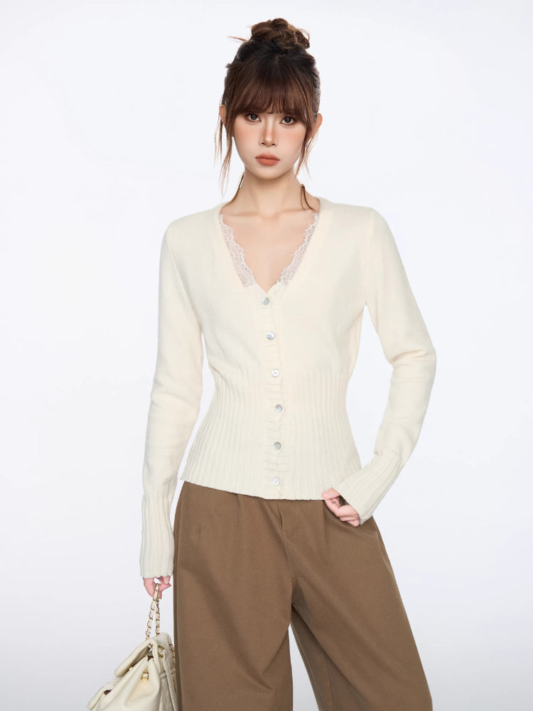 Woman wearing a cream knit cardigan with lace trim and button front, paired with brown wide-leg pants.