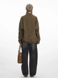 Back view of a woman in a brown herringbone bomber jacket.