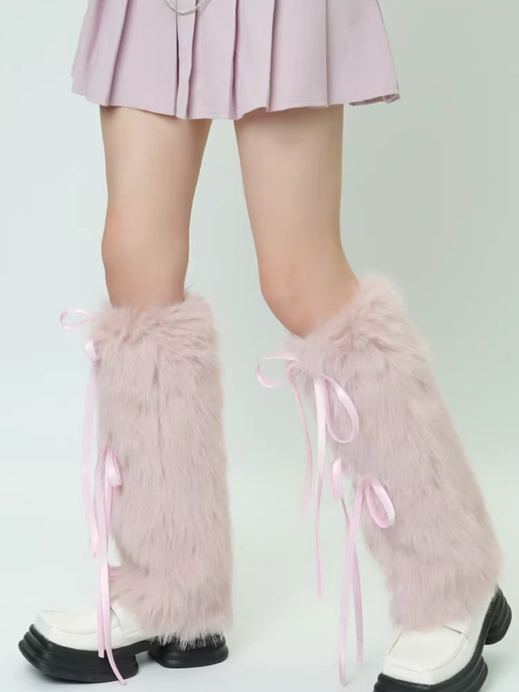 Full view of pink faux fur leg warmers with ribbon ties, paired with white shoes and a pink skirt.