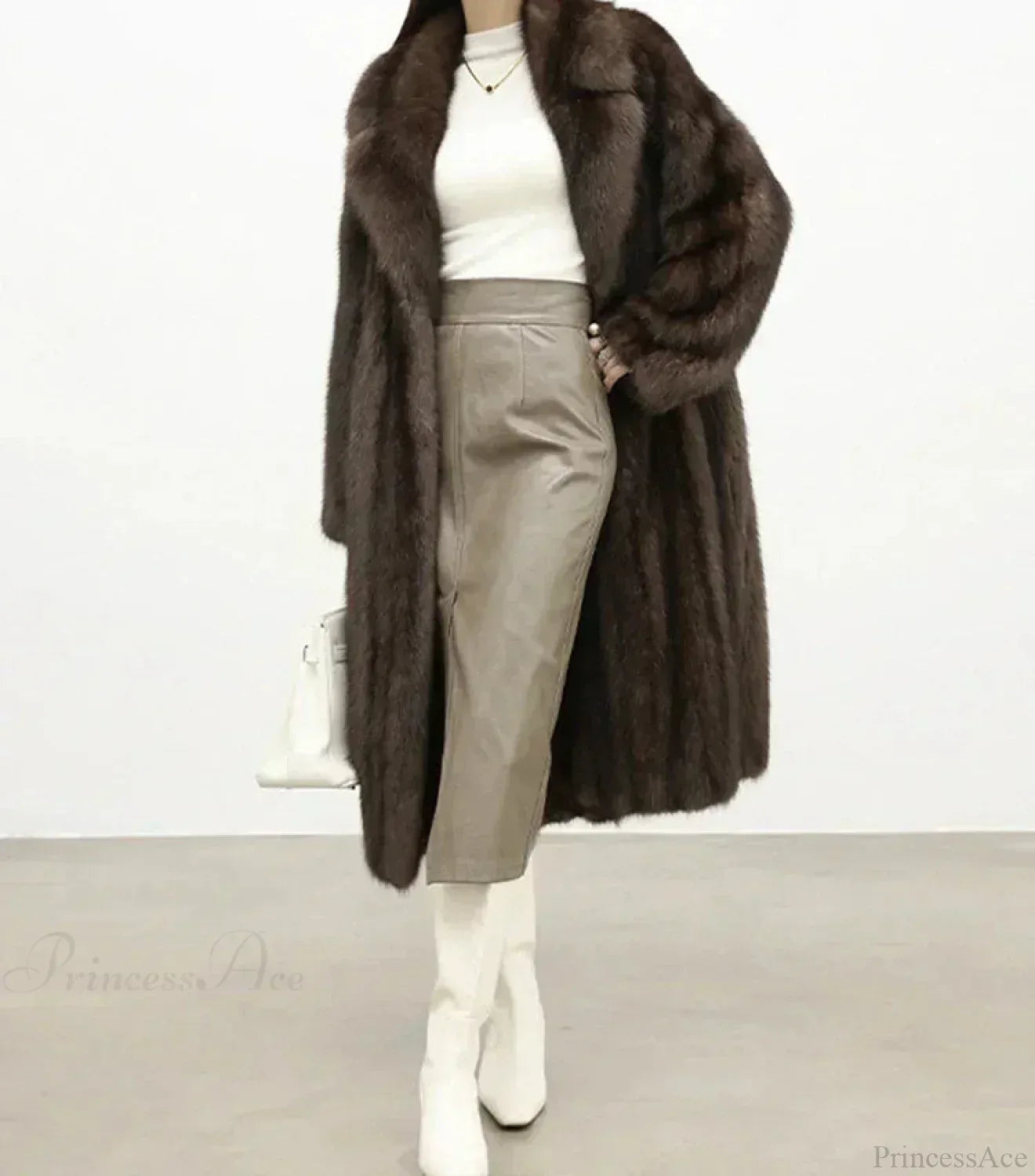 Woman wearing a full-length brown mink fur coat with a notched collar and white turtleneck, paired with a grey leather pencil skirt and white boots. Main image