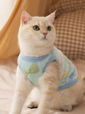Cat wearing a light blue fleece vest with cartoon print