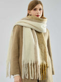 Close-up of a woman modeling a warm, striped scarf with a soft texture and tasseled ends.